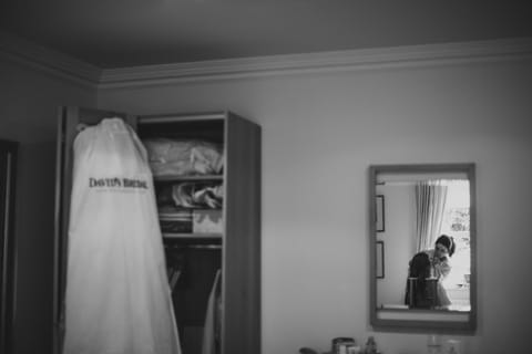 bride having her hair done in the mirror