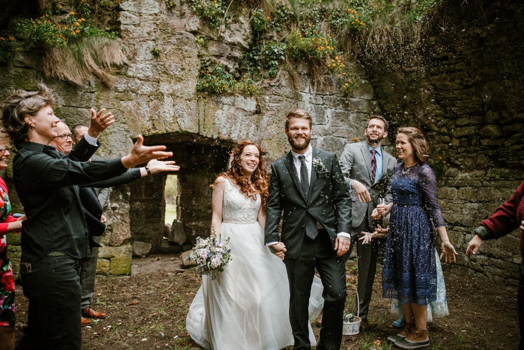 Coastal intimate Wedding in Ireland the wedding party throwing confetti at theri intimate wedding