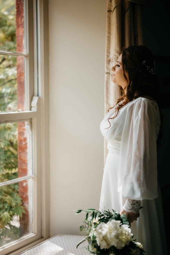 An Elegant Spring Elopement in West Cork at Bantry House - bride looking over Bantry bay from her window in bantry house 